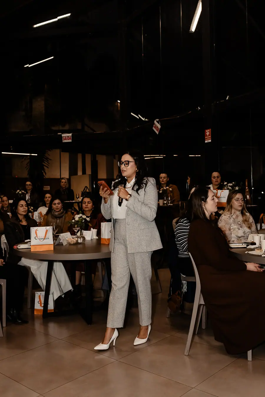 Cynthia conduzindo, com a sala sentada à frente
